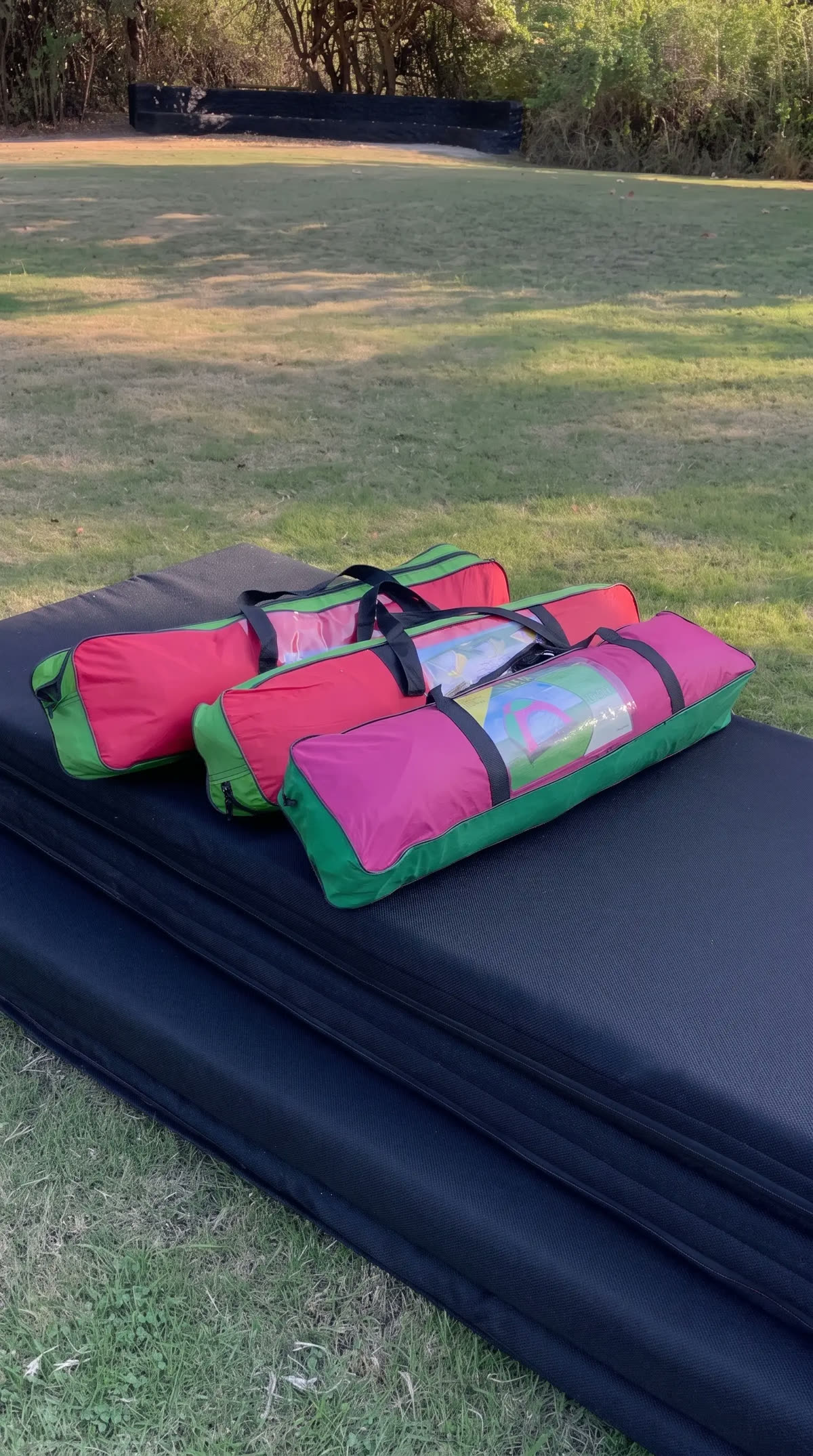 Folded black mattresses with tent bags on top