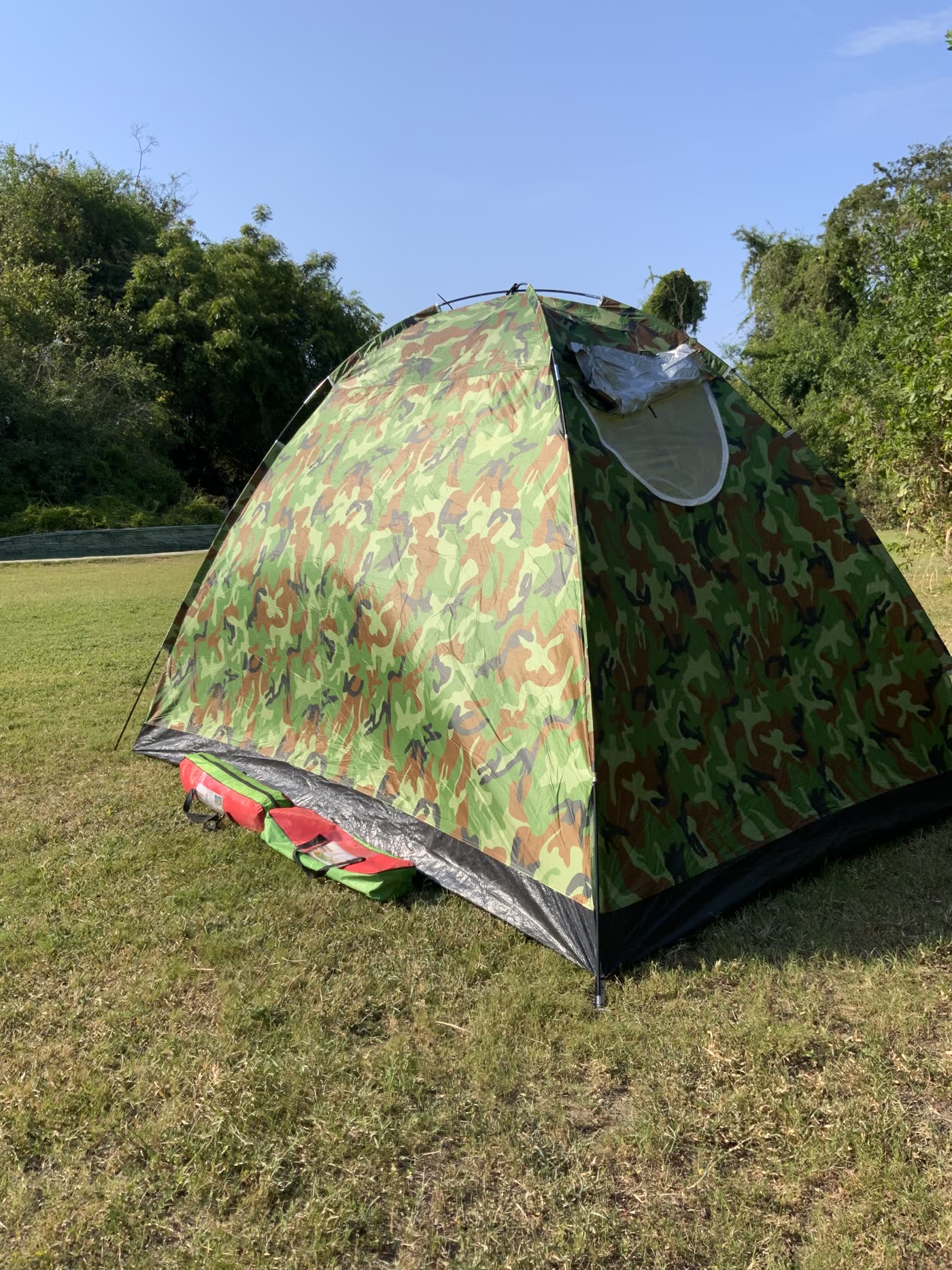 Tent set up beside its carry bag